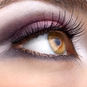 Close up of a woman's hazel coloured right eye with long eye lashes.