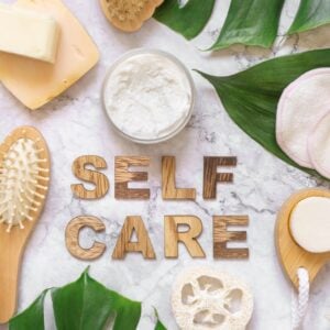 Self Care text near cosmetics, skin and hair care accessories.